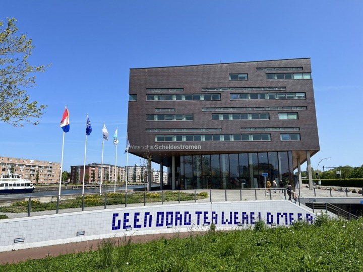 Het kantoor in Middelburg met de op de voorgrond een fietstunneltje en vlaggenmasten.